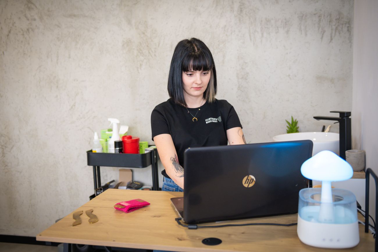 Fizjoterapeutka Agata Wasilewska pracująca na komputerze