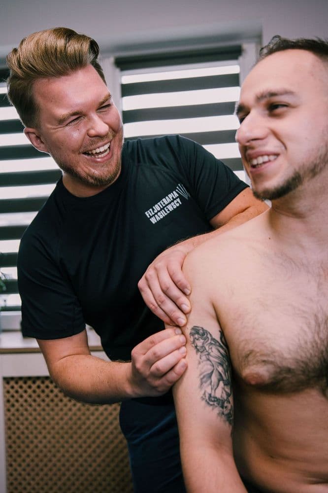 Uśmiechnięty fizjoterapeuta w gabinecie Fizjoterapia Wasilewscy